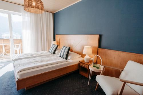 ザンクト・カンツィアン・アム・クロッパイナー・ゼーにあるHotel Greifの青い壁のベッドルーム1室(大型ベッド1台付)