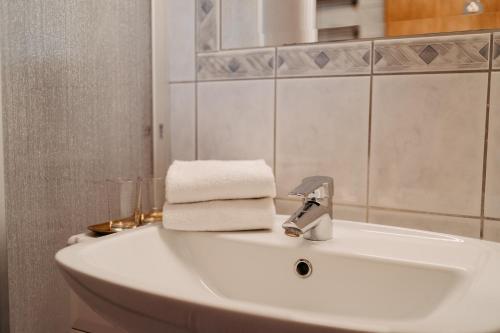 un lavabo blanco en el baño con toallas. en Hotel Greif, en Sankt Kanzian