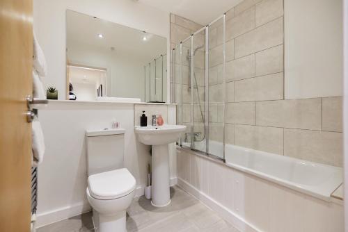 a bathroom with a toilet and a sink and a shower at The Putney Escape - Trendy 2BDR Flat with Terrace + Parking in London
