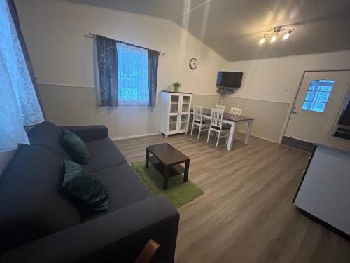 ein Wohnzimmer mit Sofa und Tisch in der Unterkunft Ekokatti Cottages in Vuokatti