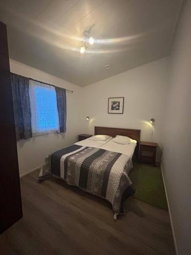a bedroom with a bed in a room with a window at Ekokatti Cottages in Vuokatti