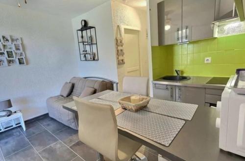 une petite cuisine avec une table et un canapé dans l'établissement Studio cabine avec parking privé, à Valras-Plage
