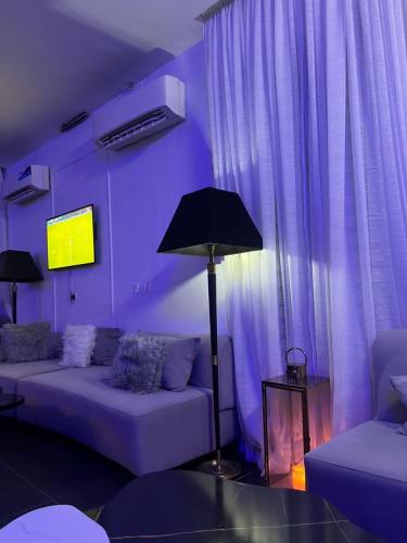 a purple living room with a couch and a lamp at BLOCK 58 in Lagos