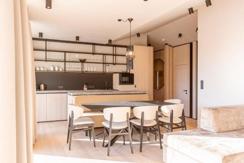 Kitzbühel Suites by ALPS RESORTS في أوبيرندورف إن تيرول: مطبخ وغرفة طعام مع طاولة وكراسي