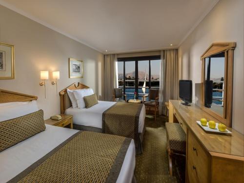 a hotel room with two beds and a television at Steigenberger Regency Nile Cruise - Every Saturday from Luxor for 07 & 04 Nights - Every Wednesday From Aswan for 03 Nights in Luxor