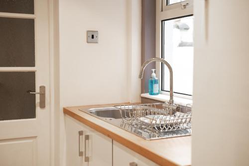 a kitchen counter with a sink and a window at Well decorated 2 bed home in Handbridge, Chester in Hough Green