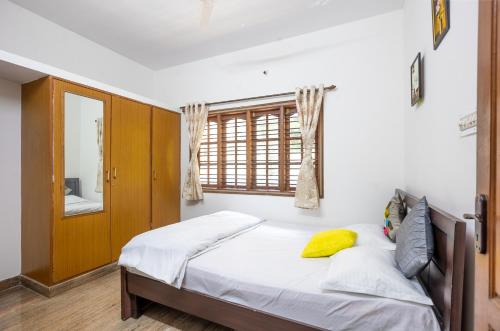 - une chambre avec un lit, un miroir et une fenêtre dans l'établissement Shree Miththam Apartment, à Bangalore