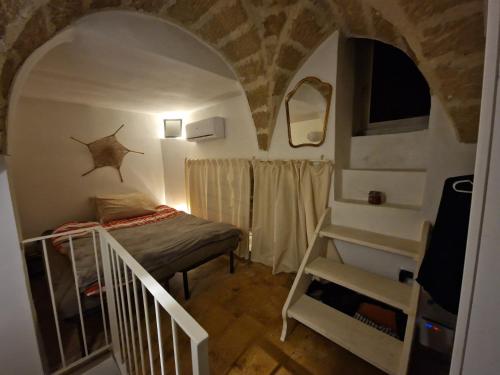 een kleine kamer met een stapelbed en een trap bij Casa Mignano in Gallipoli