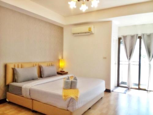 Un dormitorio con una cama grande y una ventana en ตาฟ้าเรสซิเดนซ์ (Tafah Residence), en Sakon Nakhon