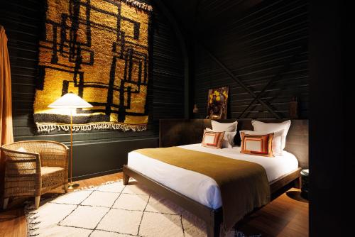 a bedroom with a large bed and a lamp at Safari Suite Zoo de la Flèche in La Flèche