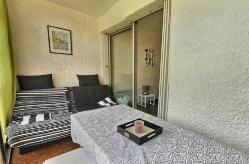 - une chambre avec un lit et un grand miroir dans l'établissement Studio cabine avec parking privé, à Valras-Plage