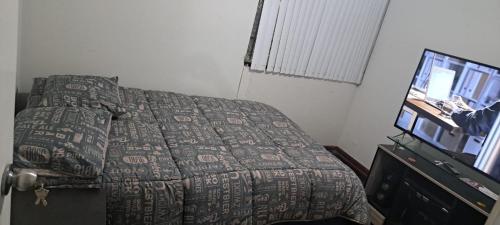 a bedroom with a bed and a flat screen tv at Departamento Completo Zona residencial la Molina in Lima