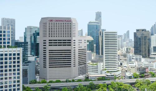 Crowne Plaza Bangkok Lumpini Park, an IHG Hotel في بانكوك: أفق المدينة مع المباني الطويلة والطريق السريع