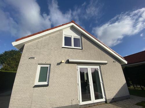 a white brick house with white windows on it at Chateau Noordwijk in Noordwijk