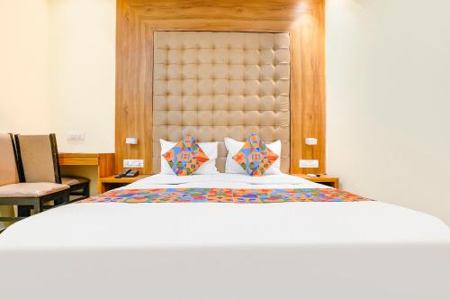 1 dormitorio con 1 cama grande y cabecero grande en FabHotel Cozy Inn en Bombay