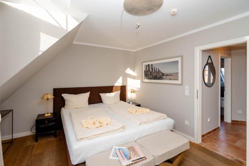 - une chambre avec un grand lit et des draps blancs dans l'établissement Ferienhaus Ekke Nekkepenn1, à Westerland