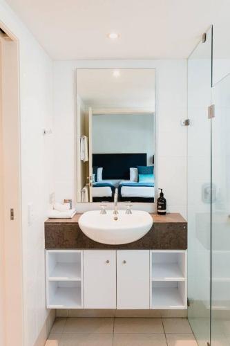 a bathroom with a sink and a mirror at Bottlebrush: A Beachside Resort Paradise in Palm Cove