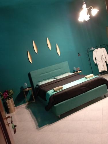 a bedroom with a bed with a blue wall at Terrazza Filangiò in Caserta