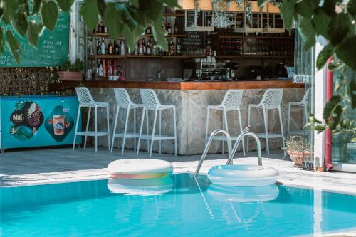 a swimming pool with two stools and a bar at Georgia's Garden by Omilos Hotels in Amoudara Herakliou