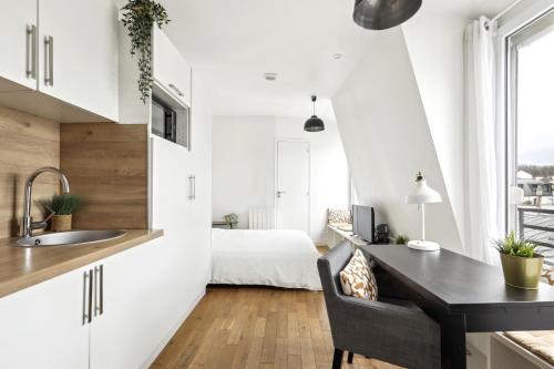 - une cuisine avec un bureau et un lit dans une chambre dans l'établissement Bright top floor studio near Pere Lachaise, à Paris