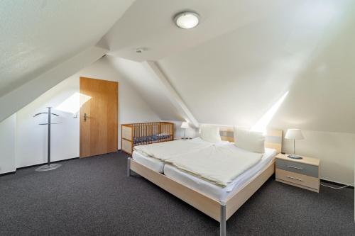 - une chambre mansardée avec un lit blanc dans l'établissement Wanderlust Wernigerode - Dein Tor zum Harzer Abenteuer, à Wernigerode