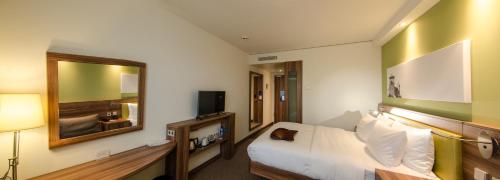 a hotel room with a bed and a mirror at Hampton by Hilton Nürnberg City Center in Nuremberg