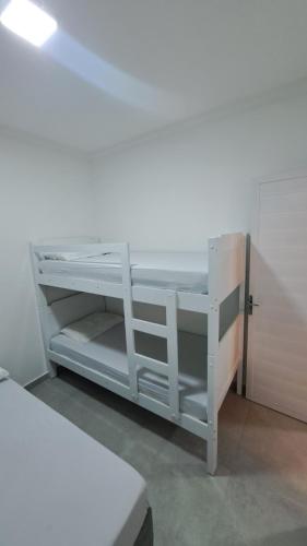 ein weißes Etagenbett in einem Zimmer in der Unterkunft Flats Praia Dourada in Maragogi