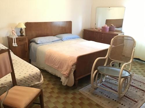 una camera con letto, sedia e specchio di Casa indipendente casa costa a Costa Pallavieino