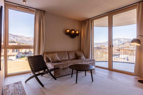 a living room with a couch and a table at Kitzbühel Suites by ALPS RESORTS in Oberndorf in Tirol
