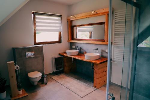 łazienka z 2 umywalkami i toaletą w obiekcie Leśny Zakątek w mieście Jurków