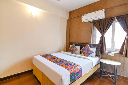 a bedroom with a large bed and a window at FabExpress Krishna in Kolkata
