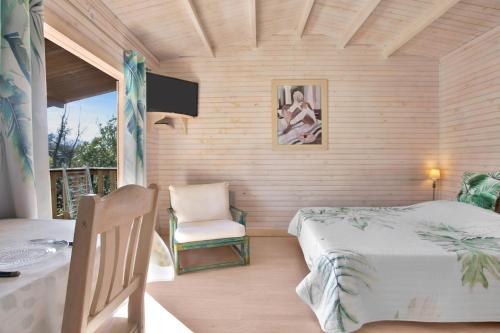 a bedroom with a bed and a table and a chair at Superbe Chalet in Roquebrune-sur-Argens