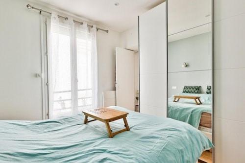 een slaapkamer met een tafel op een bed met een spiegel bij Paris9 in Parijs