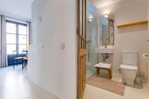 uma casa de banho com um WC, um lavatório e um espelho. em En Ville Boutique Apartments Sant Antoni em Barcelona