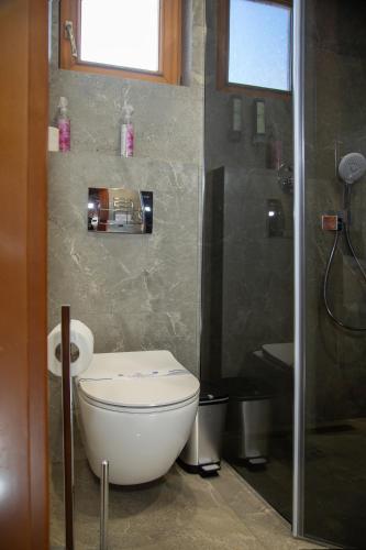 a bathroom with a white toilet and a shower at Korona Hotel&SPA in Bukovel