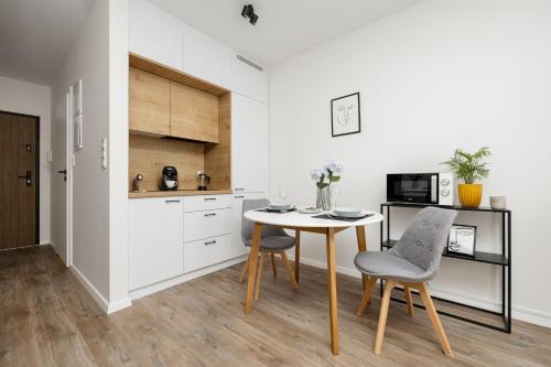 a kitchen with a table and chairs in a room at Gdańsk Przymorze Pretty Studios & Pets Allowed by Renters in Gdańsk