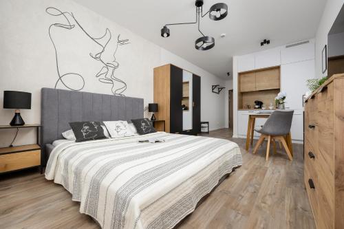 a bedroom with a large bed and a kitchen at Gdańsk Przymorze Pretty Studios & Pets Allowed by Renters in Gdańsk
