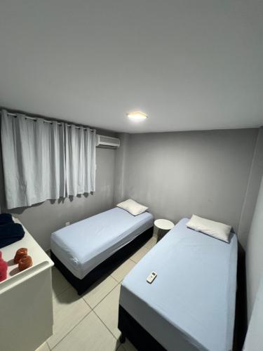 um pequeno quarto com 2 camas e uma janela em Apartamento em condomínio em Petrolina