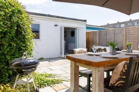 a patio with a grill and a table and chairs at Charming Bolthole 400m to Beach in Earnley