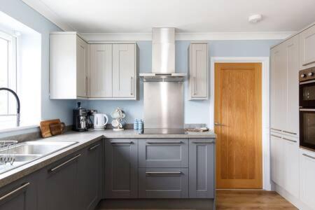 a kitchen with white cabinets and a sink at Charming Bolthole 400m to Beach in Earnley