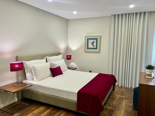 a bedroom with a large bed with white and red pillows at Casa Jerónimo B&B in Peso da Régua