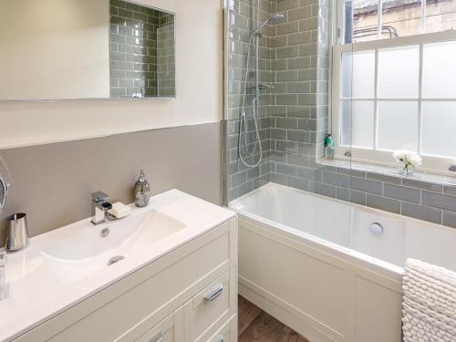 a bathroom with a sink and a tub and a mirror at 4 Bed in Darley Dale 79020 in Great Rowsley