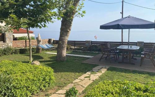 Ágios Konstantínos的住宿－Christina Sea View，庭院配有桌椅和遮阳伞。