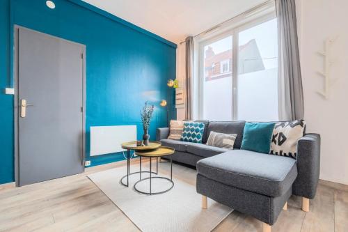 un salon avec un canapé et une chaise dans l'établissement La Madeleine - Deux pièces équipé, à La Madeleine