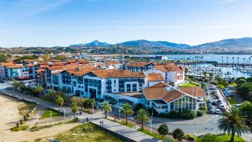 eine Luftansicht auf eine Stadt mit Yachthafen in der Unterkunft Hotel & Spa 4* Serge Blanco in Hendaye