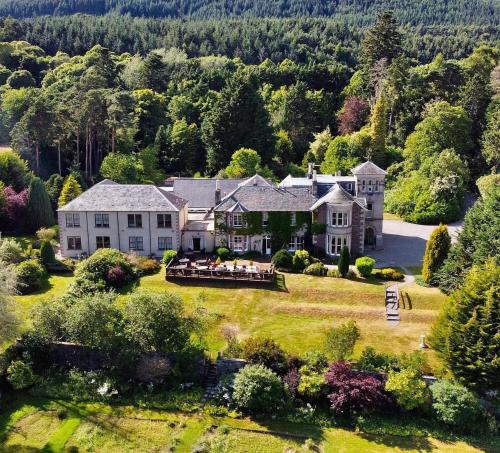 eine Luftansicht eines großen Hauses mit Bäumen in der Unterkunft Loch Ness Country House Hotel in Inverness