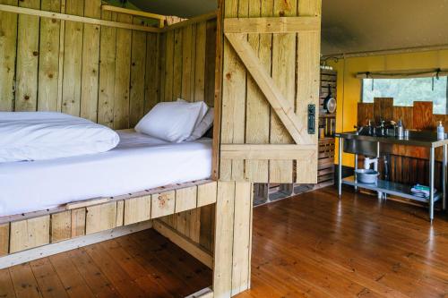 a bedroom with a bed in a room with wooden walls at Oak in Honiton