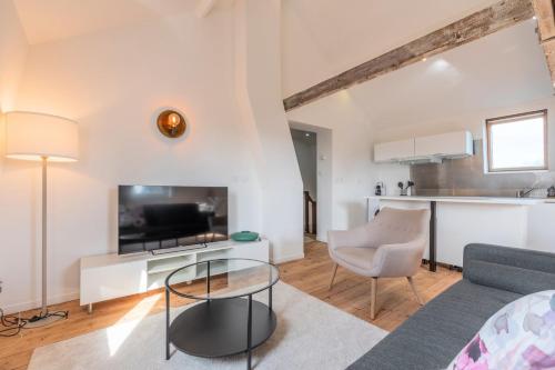 sala de estar con sofá, TV y mesa en Charming 2-bedroom apartment at Croisé Laroche en Marcq-en-Baroeul