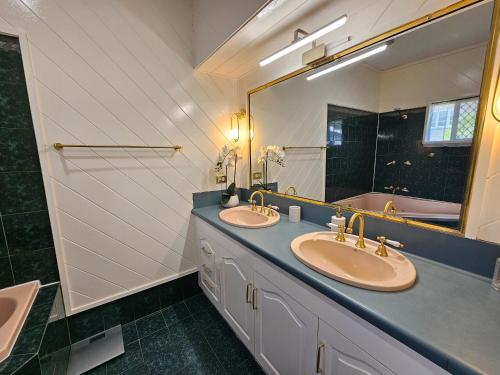 a bathroom with two sinks and a large mirror at Gateway to Paradise in Westcourt