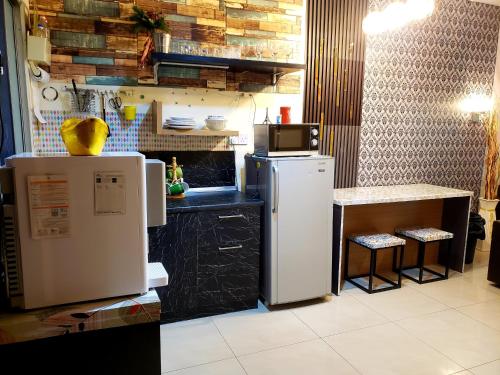 a kitchen with a refrigerator and a counter with a table at The Mons inside Tower Regency Hotel and Apartments in Ipoh